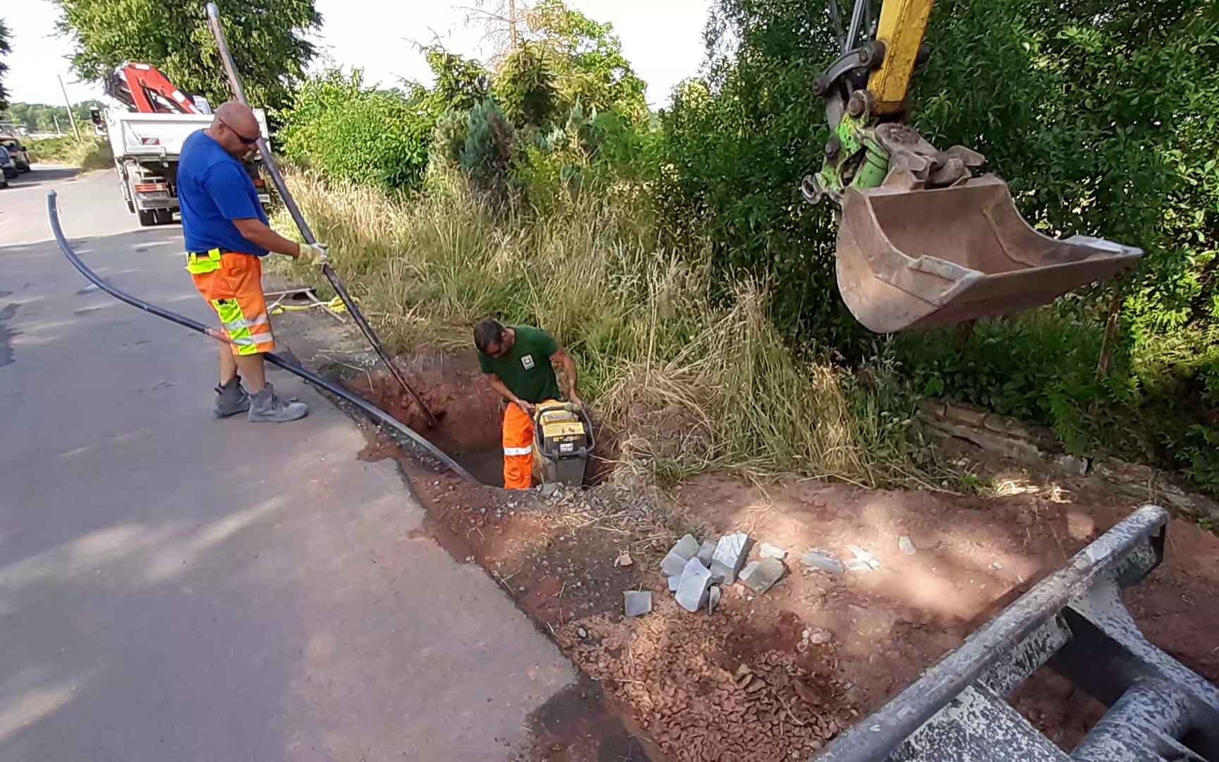 Bauarbeiter graben eine Grube für Kabelverlegung.